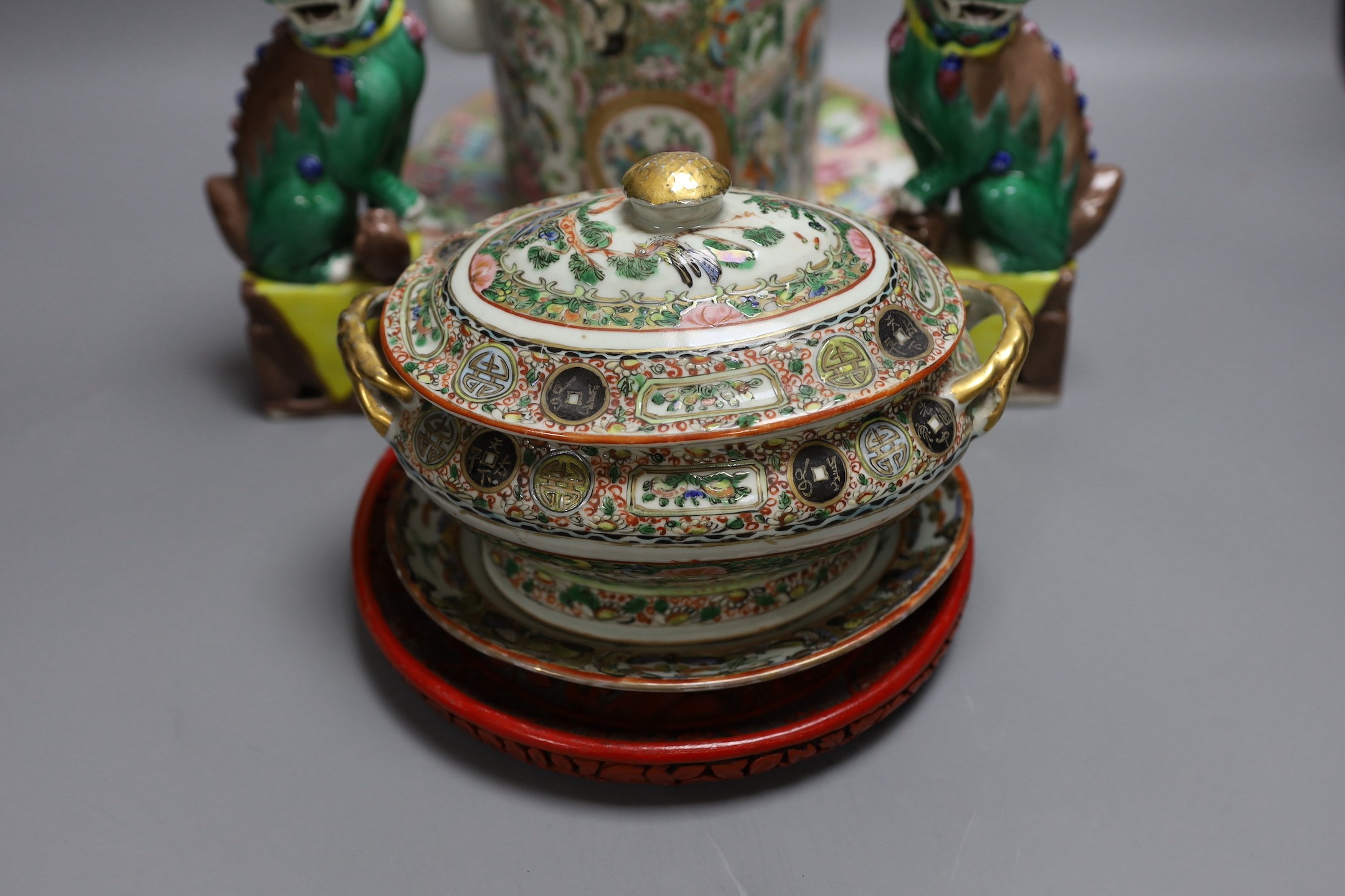 A Cantonese famille rose plate and teapot with cover, a pair of Chinese seated dogs, and a tureen with cover and oval dish, And a Chinese faux lacquer dragon and Phoenix dish, teapot 18 cms high